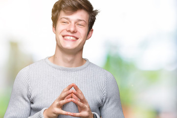 Young handsome man wearing winter sweater over isolated background Hands together and fingers crossed smiling relaxed and cheerful. Success and optimistic