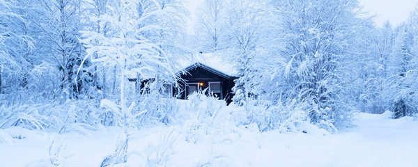 Log house in the snow-covered forest. Traditional Finnish buildings.  Finland Lapland