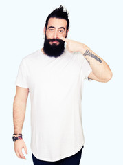 Young hipster man with long hair and beard wearing casual white t-shirt Pointing with hand finger to face and nose, smiling cheerful