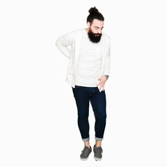 Naklejka premium Young hipster man with long hair and beard wearing sporty sweatshirt Suffering of backache, touching back with hand, muscular pain
