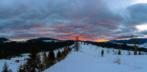 Traveling photographer admires the beautiful sunrise on the top of Carpathian mountains