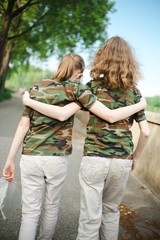 Two teenaged friends in camouflage t shirts.