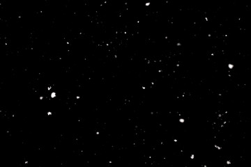 Snowstorm texture. Bokeh lights on black background, shot of flying snowflakes in the air