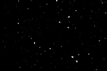 Naklejka na ściany i meble Snowstorm texture. Bokeh lights on black background, shot of flying snowflakes in the air