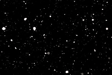 Snowstorm texture. Bokeh lights on black background, shot of flying snowflakes in the air