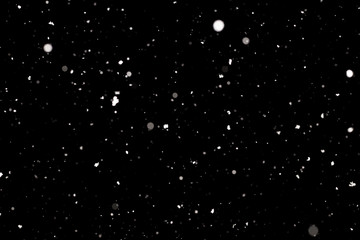 Naklejka na ściany i meble Snowstorm texture. Bokeh lights on black background, shot of flying snowflakes in the air