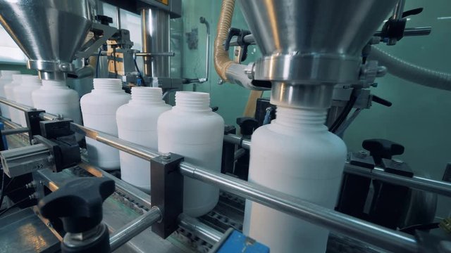 Factory machines filling plastic bottles, automatic process.