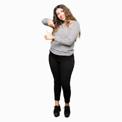 Young beautiful woman wearing stripes sweater In hurry pointing to watch time, impatience, upset and angry for deadline delay