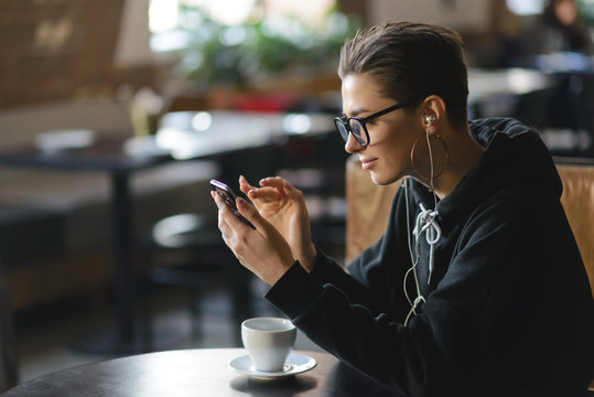 Shortcut Hipster Woman Enjoys Music She Is Streaming To Her Smartphone Via Her Headphones