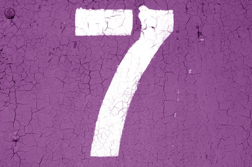 Number 7 in stencil on metal wall in purple tone.