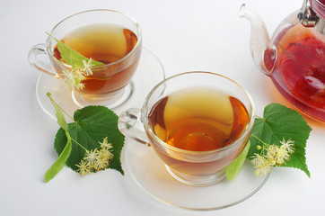   Tea with linden flowers. Two cups of tea and linden flowers and leaves
