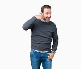 Fototapeta premium Handsome middle age senior man wearing a sweater over isolated background smiling doing phone gesture with hand and fingers like talking on the telephone. Communicating concepts.