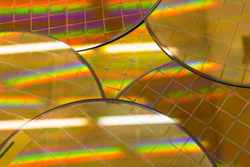 Several Silicon Wafers with microchips - A wafer is a thin slice of semiconductor material, such as a crystalline silicon, used in electronics for the fabrication of integrated circuits.