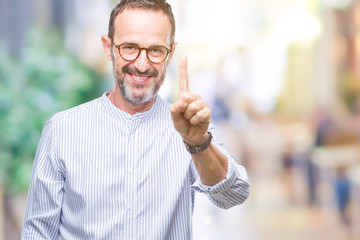 Middle age hoary senior man wearing glasses over isolated background showing and pointing up with finger number one while smiling confident and happy.
