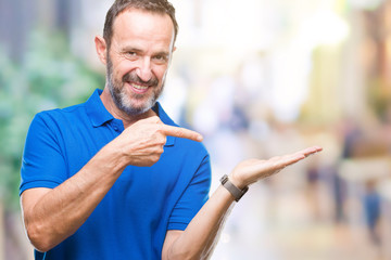 Middle age hoary senior man over isolated background amazed and smiling to the camera while presenting with hand and pointing with finger.