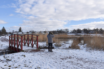 Birder by a pond in winter season