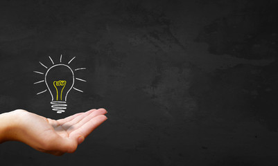 Chalkboard & Hand Showing Light Bulb