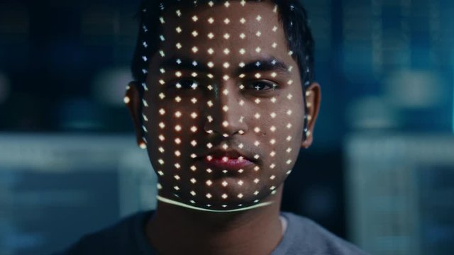 Handsome Young Indian Man is Identified by Biometric Facial Recognition Scanning Process. Futuristic Concept: Projector Identifies Individual by Illuminating Face by Dots and Scanning with Laser