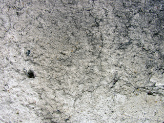 Dirty gray concrete weathered damaged wall texture with cracks and cavities