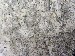 Dirty gray concrete wall texture with cracks and cavities