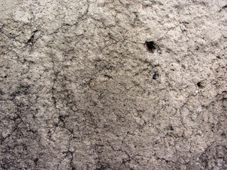 Dirty gray concrete weather exposure wall texture with cracks and cavities