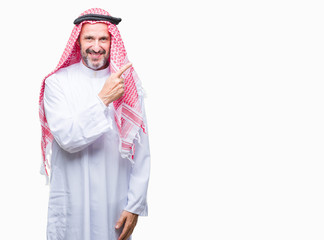 Senior arab man wearing keffiyeh over isolated background cheerful with a smile of face pointing with hand and finger up to the side with happy and natural expression on face looking at the camera.