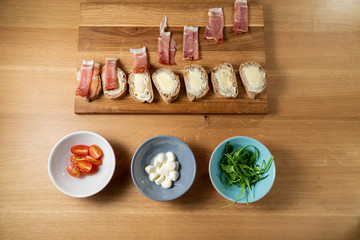 Small party sanwiches on wooden board on wooden table with proscuitto arriving Happy Sandwiches Part 5 from 9