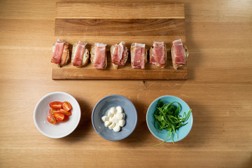 Small party sanwiches on wooden board on wooden table covered with proscuitto Happy Sandwiches Part 6 from 9