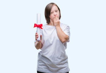 Young adult woman with down syndrome holding degree over isolated background cover mouth with hand shocked with shame for mistake, expression of fear, scared in silence, secret concept