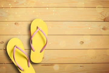 Yellow rubber sandals flip flops on wooden background