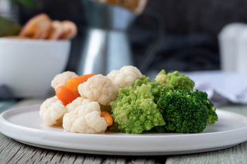 Cooked vegetables on a plate, vegetarian food.