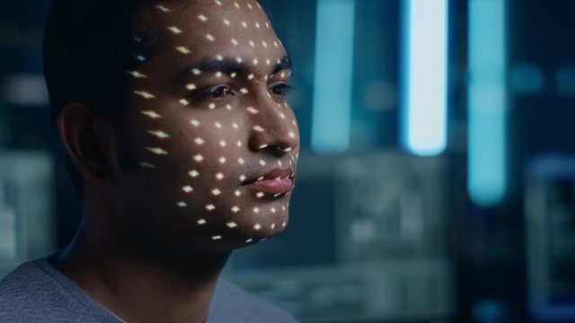 Handsome Young Indian Man is Identified by Biometric Facial Recognition Scanning Process. Futuristic Concept: Projector Identifies Individual by Illuminating Face by Dots and Scanning with Laser