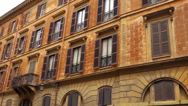 Beautiful european urban architecture. Exterior of old residential building in center of Rome, Italy. Colorful facade of roman house. Camera moving sideways, dolly shot