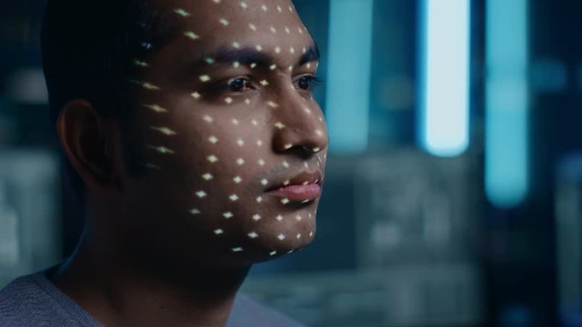Handsome Young Indian Man is Identified by Biometric Facial Recognition Scanning Process. Futuristic Concept: Projector Identifies Individual by Illuminating Face by Dots and Scanning with Laser