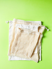 Empty cotton bags on green background