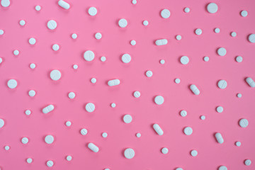 White pills on pink background. Copy space for text