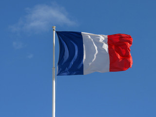 Naklejka na ściany i meble French fabric Tricolour flag of France flapping in the wind with copy with blue sky background