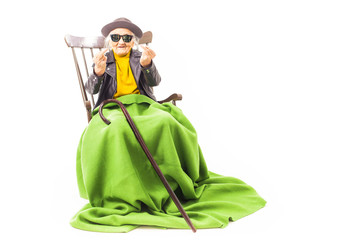 Old woman with sunglasses sitting on a chair.