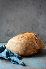 Homemade Freshly Baked Country Bread  made from wheat and whole grain flour on a gray-blue background. French bread