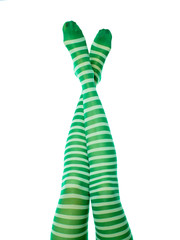 Female long legs in green striped stockings. Leprechaun girl, isolated on white