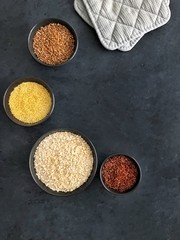Red rice, buckwheat, millet and oatmeal on dark background