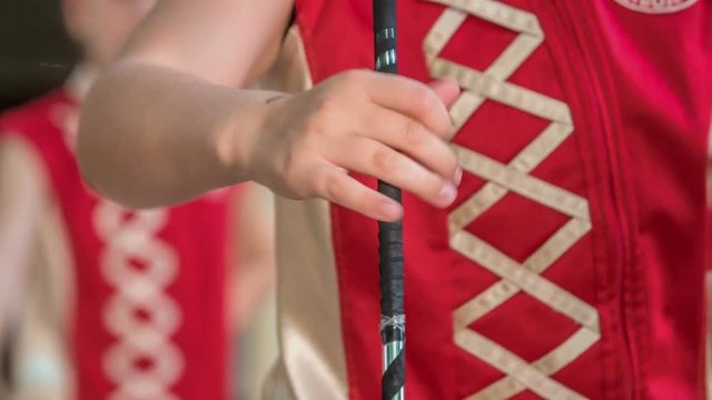 Girls are turning the majorette stick with one hand. They're really good at this routine.