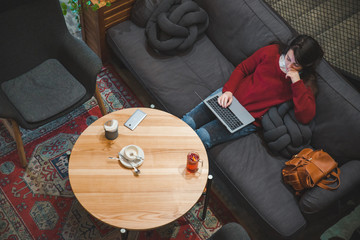 woman sitting in cafe using laptop drinking tea. white screen. copy space