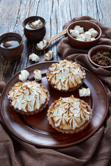 Lemon meringue tartlets on a clay plate