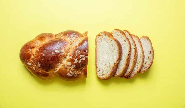 Easter bread, greek tsoureki braid on yellow color, top view