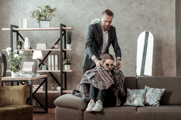 Loving father covering his daughter feeling stressed with plaid