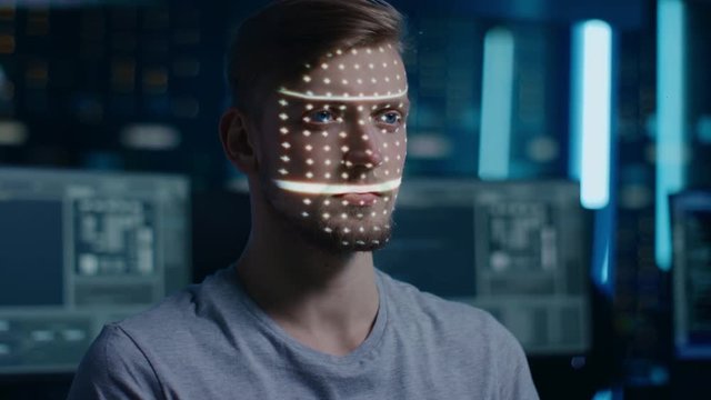 Handsome Young Caucasian Man is Identified by Biometric Facial Recognition Scanning Process. Futuristic Concept: Projector Identifies Individual by Illuminating Face by Dots and Scanning with Laser