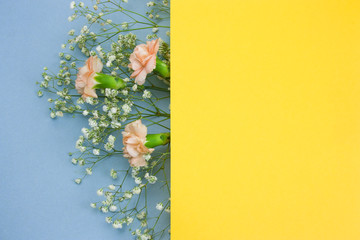 blank yellow paper sheet and bouquet of flowers frame on blue background