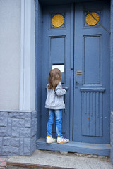 little girl in front of a door