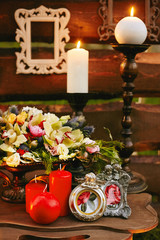 Beautiful red and white burning candles with exotic flowers on the table